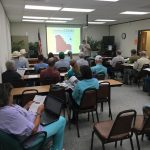 2018 annual workshop _Fall A classroom of people sit and watch a presentation
