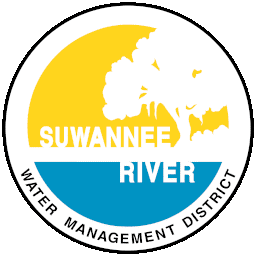 SRWMD Suwannee River Water Management District Logo contains yellow upper half circle and blue lower half circle with a white tree silhouette and Suwannee River written in white, all encircled by a blue ring and the words "Water Management District" below.